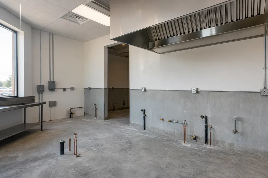 Concept view of utility connections for commercial equipment planning Empty commercial prep area with visible utility connection points