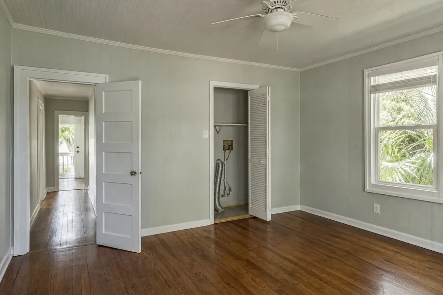 Concept view of an existing room before a possible ADU conversion Empty residential room with doorway, window, and visible utility access